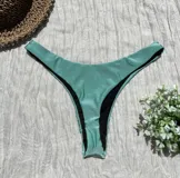 Conjunto de bikini verde agua, con corpiño de un hombro y bombacha colaless.