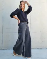 Jean de corte wide leg en color gris lavado, con tiro alto y ruedo deshilachado.