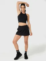 Top deportivo negro de sujeción media, con diseño de cuello alto y espalda cruzada. Confeccionado en tejido con tecnología de aloe vera para mayor suavidad.