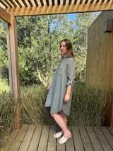 Vestido camisero color beige claro, de lino 100% natural, con botones de nácar, bolsillo delantero y mangas 3/4 con botón para recogerlas. Diseño asimétrico, más largo en la parte trasera.