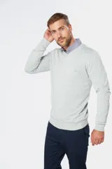 Suéter de tejido fino color azul marino, con cuello en V y manga larga. Presenta un pequeño logo bordado en el pecho.