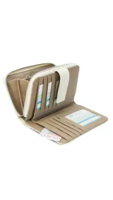 Billetera mediana con diseño combinado de símil cuero y tejido tipo telar en color beige. Cuenta con cierre perimetral, presilla con broche y múltiples compartimentos internos para tarjetas, billetes y monedas.