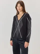 Buzo de lana con escote en V, diseño de rombos con detalles en hilo de lurex brillante. Presenta mangas largas y un corte recto.