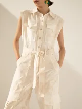 Mono color verde oliva, con cuello camisero, sin mangas, bolsillos frontales y laterales tipo cargo, y cinturón de lazo.