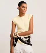 Blusa ajustada de tejido rib de algodón color amarillo pálido, con cuello redondo y mangas cortas que simulan hombreras o almohadillas.