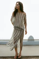 Vestido midi de Zara Woman Collection, con estampado de rayas verticales y detalles ornamentales, escote en V, mangas cortas con aberturas en los hombros, y fajín integrado con lazo lateral del mismo tejido.