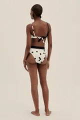 Bombacha de bikini de corte alto a la cintura, color blanco con lunares negros y faja ancha negra.