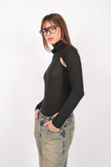 Body gris de tejido de punto con cuello alto y mangas largas. Presenta aberturas en los hombros, broches snap en la entrepierna y elástico interno en el contorno de tiro.