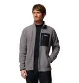 Campera polar de textura suave y cálida, con cierre frontal completo y cuello alto. Presenta un bolsillo en el pecho con cierre y revestimiento de contraste, además de bolsillos laterales. El diseño incluye puños y dobladillo con ribete elástico para mayor protección.