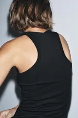 Top negro de corte ajustado (slim fit) con escote redondo y manga sisa.