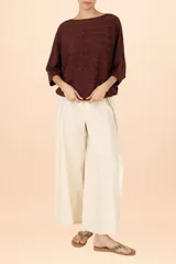 Suéter de punto con acabado metalizado, color café, con diseño de rayas horizontales texturizadas. Presenta cuello barco, mangas tipo murciélago y un bajo ajustado.