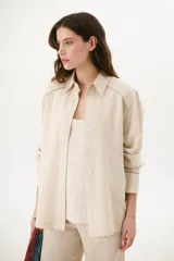 Sobrecamisa celeste de lino con cuello clásico, cierre con botones y mangas largas con puños abotonados.