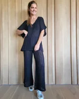 Pantalón de punto calado color crudo, de corte palazzo y cintura elástica.