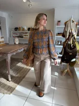 Blusa de manga larga con diseño de cuadros en tonos camel y azul, confeccionada con tejido elástico fruncido en todo el cuerpo y las mangas.