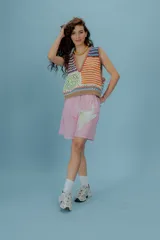 Short bermuda tableado color rosa con estampado de flor blanca.