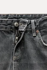 Jeans de tiro bajo con diseño wide leg y corte full length. Presenta cinco bolsillos, cierre frontal con cremallera y botón metálico, en un lavado de denim claro.