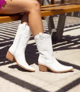 Bota texana blanca de cuero con bordados decorativos y taco de madera.