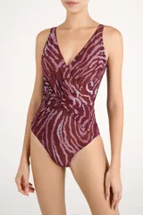 Malla enteriza con estampado animal print tipo cebra en tonos bordó y rosado, con escote en V cruzado y detalle de nudo drapeado en el centro.