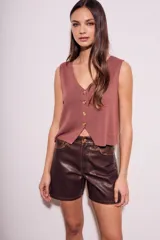 Short marrón de cuero sintético, tiro medio y corte recto.