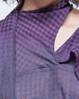 Vestido azul con estampado a cuadros, cuello con lazo y corte recto holgado con aberturas laterales.