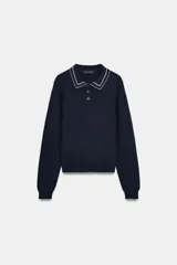 Jersey de punto color azul marino, de manga larga, con cuello polo y cierre frontal de botones. Presenta vivos blancos con borde ondulado en el cuello, puños y ruedo inferior.