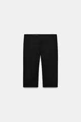 Pantalón capri negro de tiro medio con aberturas laterales en el bajo y cierre lateral con cremallera oculta.