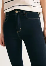 Pantalón de jean corte skinny, de tiro medio y color azul oscuro con costuras en contraste.