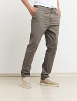 Pantalón de gabardina de corte recto y tiro medio, con bolsillos laterales y traseros, y cierre frontal con botón y cremallera.