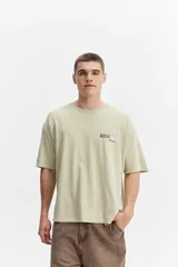 Remera boxy de algodón color verde claro con efecto lavado, de corte amplio y mangas cortas. Presenta un pequeño estampado en el pecho con la inscripción "RISK mistral".