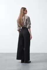 Pantalón wide leg negro de algodón con elastano, de tiro alto y caída recta. Presenta pespuntes a contratono.