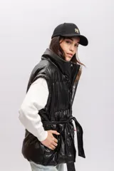 Chaleco puffer marrón de cuero sintético con cuello alto y cierre frontal con botones a presión.