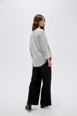 Blusa de viscosa color bordó, con cuello en V, cierre frontal parcial con botones, mangas tres cuartos y bolsillo aplicado en el pecho.