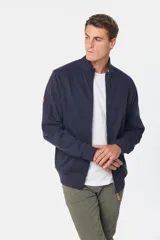 Campera de felpa color tostado con cuello alto, cierre frontal completo y puños y ruedo acanalados.