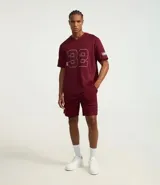 Bermuda deportiva para hombre, color bordó, con tecnología Dry que facilita la evaporación del sudor. Presenta cintura elástica con cordón interno, bolsillos y estampa lateral con lettering.