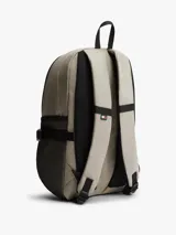 Mochila outdoor Tommy Jeans color beige con base negra, bolsillo principal con cierre, bolsillos laterales de red y asa superior. Cuenta con detalles distintivos de la marca y logo bordado en el frente.