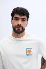 Remera oversize de manga corta color celeste, de corte relajado y amplio, confeccionada en algodón. Presenta un gran estampado en la espalda dividido en cuatro paneles con motivos gráficos (un sol, peces, ondas y formas abstractas) junto con inscripciones de la marca y estilo de vida.