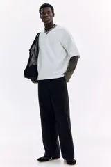 Pantalón en mezcla de algodón color negro, con cintura elástica con cordón de ajuste y botón. Presenta bolsillos laterales discretos y costuras giradas en las piernas, con un corte relajado.