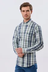 Camisa de manga larga de calce slim, con diseño a cuadros en tonos azul oscuro, verde y blanco. Presenta cuello camisero con botones y bolsillo ojal en el pecho con detalle bordado.
