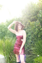 Vestido corto negro con diseño cut-out en la cintura, estilo strapless y ruedo decorado con flecos largos.