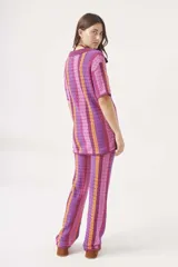 Pantalón largo de tejido crochet con rayas verticales en tonos azul, verde, marrón y blanco.