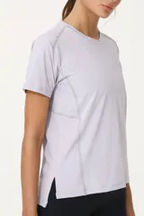 Remera deportiva lila de poliéster y elastano, con recortes laterales y traseros.