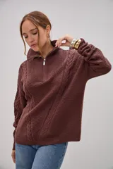 Sweater de punto color marrón chocolate, con cuello alto y cierre frontal parcial. Presenta un diseño con texturas combinadas, incluyendo paneles de punto trenzado en las mangas y el frente, y un tejido de punto texturizado en el centro.