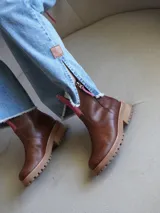 Botas de cuero color crema con cierre lateral y elástico en los laterales. Suela track color caramelo.