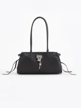 Cartera Kate de cuero vacuno diseñada para llevar al hombro, con cierre principal y bolsillo interno. Presenta aplique de candado y llavero tipo birkin en el frente, además de tiras laterales decorativas.