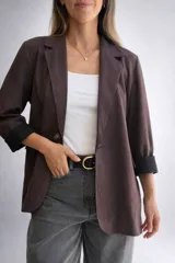 Blazer de línea italiana con textura efecto ante, de corte recto y diseño clásico. Presenta solapas frontales, cierre de un botón y bolsillos decorativos. Confeccionado en tejido suave con elasticidad.