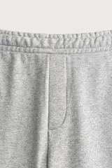 Pantalón jogger de corte relajado y pernera ancha, confeccionado en tejido de algodón con interior perchado. Cuenta con cintura elástica ajustable mediante cordón interior, bolsillos laterales y un bolsillo trasero de plastrón.