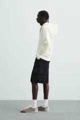 Bermuda de denim de algodón, color celeste lavado, de corte relajado (relaxed fit). Presenta cinco bolsillos, incluyendo bolsillos cargo plastrón con solapa en las perneras.