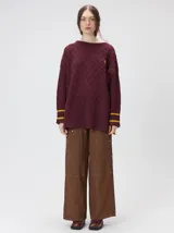 Sweater de cuello redondo con diseño de tejido en relieve de rombos, manga larga y calce holgado. Presenta logo bordado en el pecho y aberturas laterales en el ruedo.