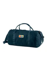 Bolso tipo duffel de lona color azul con logo de Fjällräven en el frente. Tiene doble asa de mano y correa de hombro ajustable y removible.