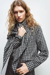 Anillo metálico de estilo sello en color dorado, con una aplicación central de pequeños cristales facetados en tonos oscuros que crean un efecto de brillo y contraste.